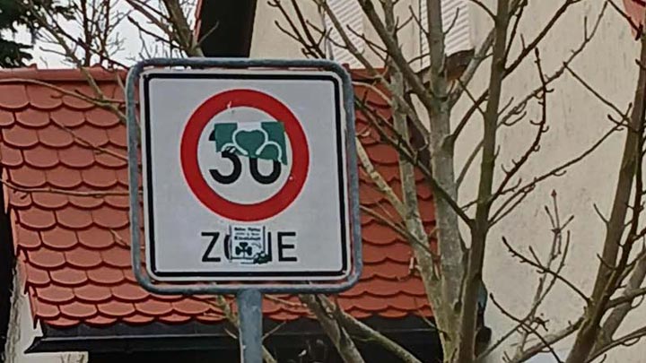 Mit Aufklebern beschädigtes Verkehrsschild