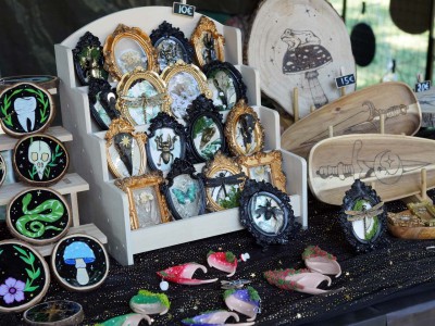 Schmuck und kleine Kunsthandwerke liegen auf einem Holztisch aus.