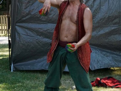 Jongleur wirft mehrere Bälle in die Luft.